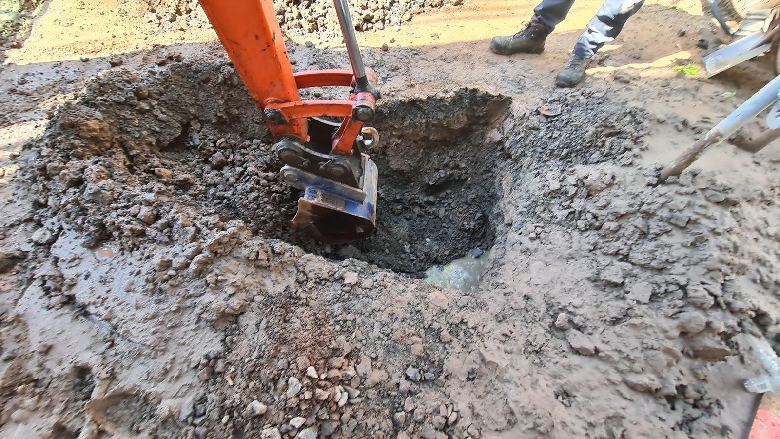 Baggerlöffel gräbt einen Leitungsgraben auf einer Baustelle
