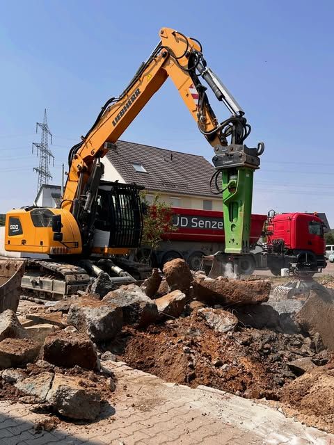 Liebherr R920C mit Hydraulikhammer beim Fundamentrückbau, dahinter der rote Lkw von JD Senzel