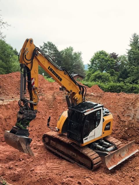 Liebherr-Kettenbagger von JD Senzel in einer Baugrube mit roter Erde